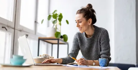 A smiling woman with career in finance using laptop