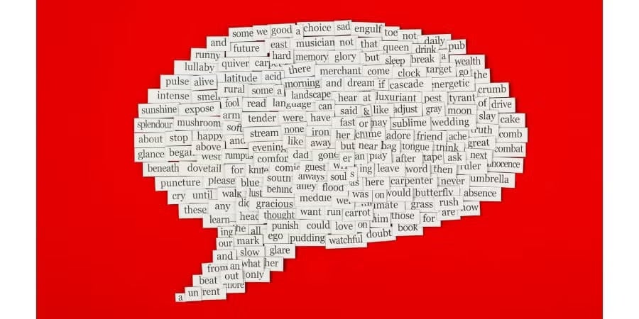 A large speech bubble made out of cut-out English words and phrases is arranged on a bright red background.